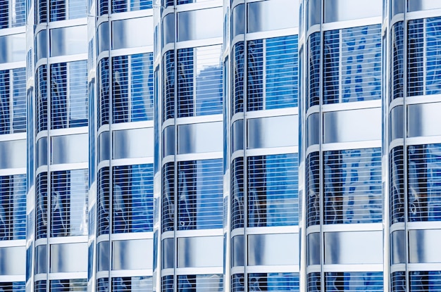 고층 빌딩의 금속 유리 외관 파란색 현대 건물의 조각 많은 창 패턴