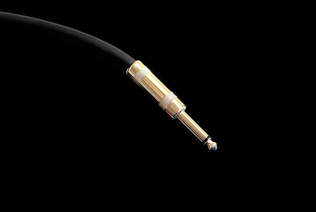 Metal golden jack connector on black audio instrumental cable isolated on white