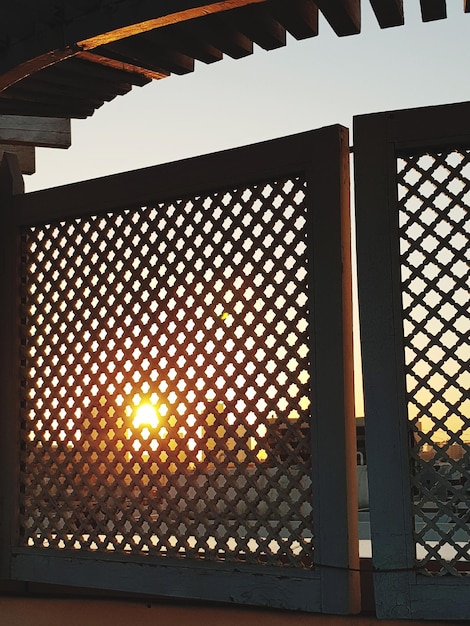 metal grate of building against sky during sunset
