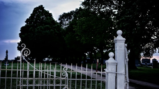 Foto griglia di metallo del cimitero al crepuscolo