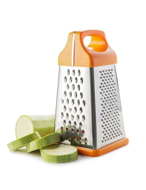 Metal grater and zucchini on white background