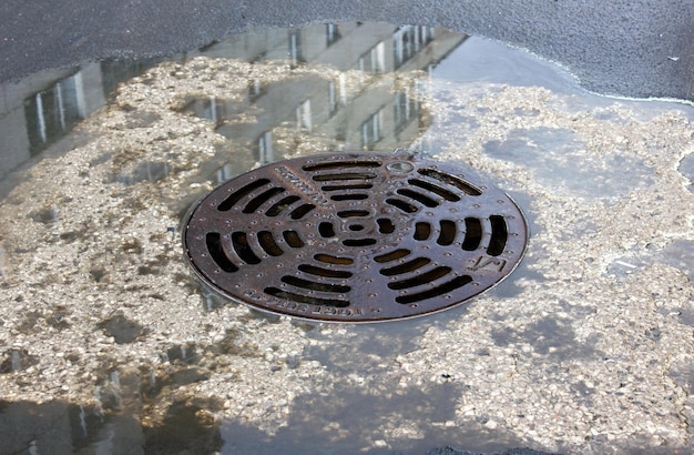 Metal hatch drain drain Water near the manhole on the street