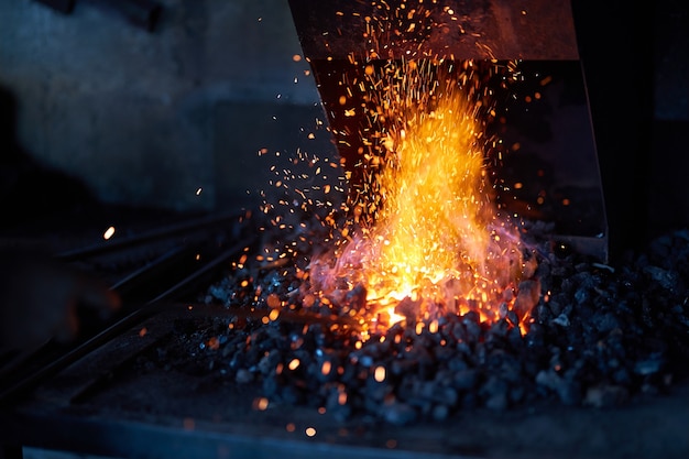 Metal heating inside burning fire at forge