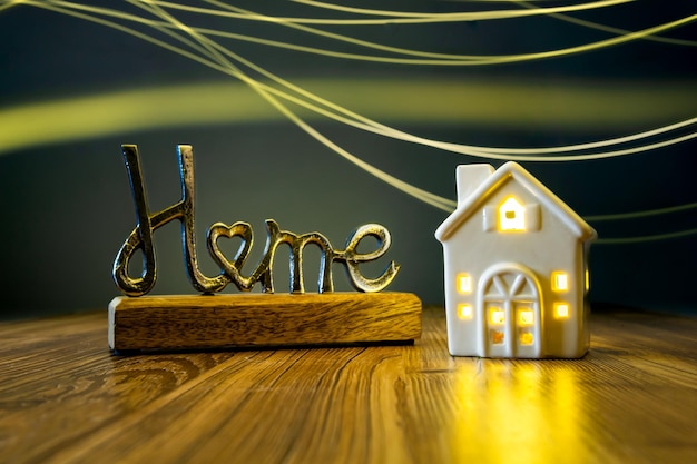 metal home sign with ceramic house and bright wavy light background housing crisis real estate agen