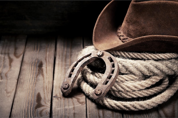 Metal horseshoe and cowboy hat on wooden