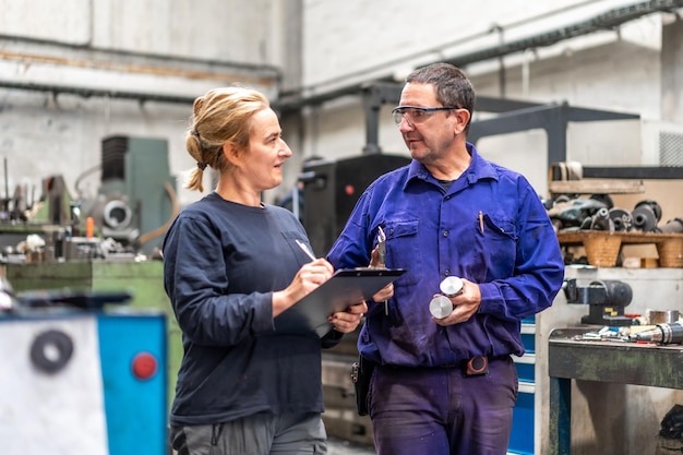 Metal industrial factory workers from the numerical control sector talking making a report