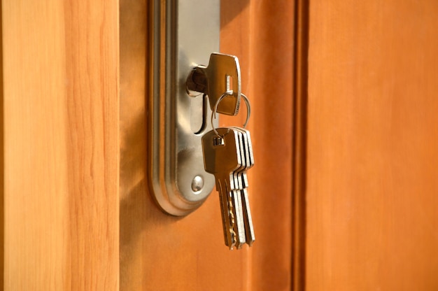 木製のドアのロックに挿入された金属製の鍵