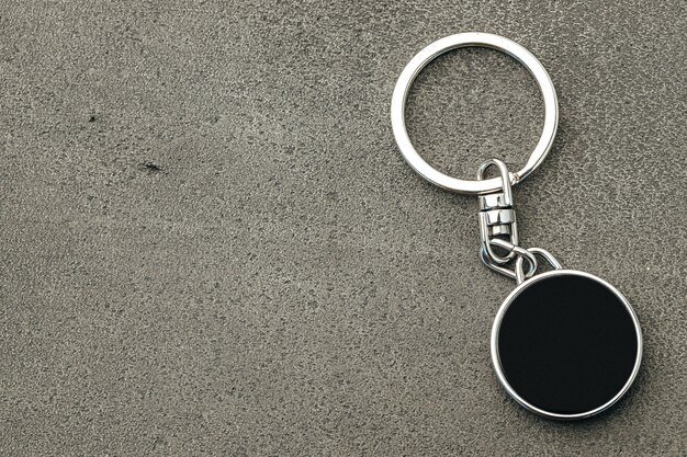 Metal key pendant on dark concrete background close up