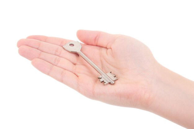 Metal key in woman hand isolated on white background