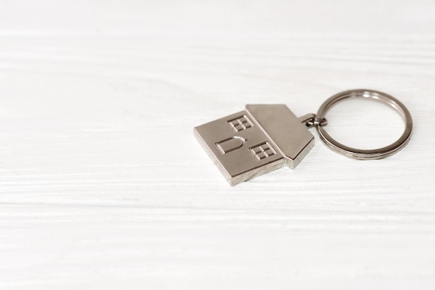 Metal keychain in the shape of a house on white