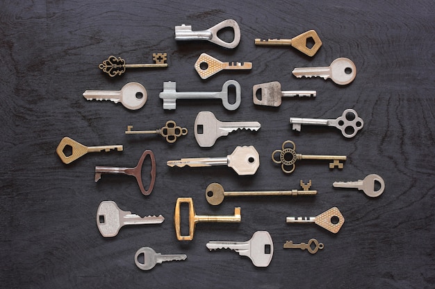 Metal keys on a black wooden background