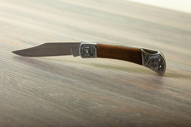 Metal knife with wooden handle on the table