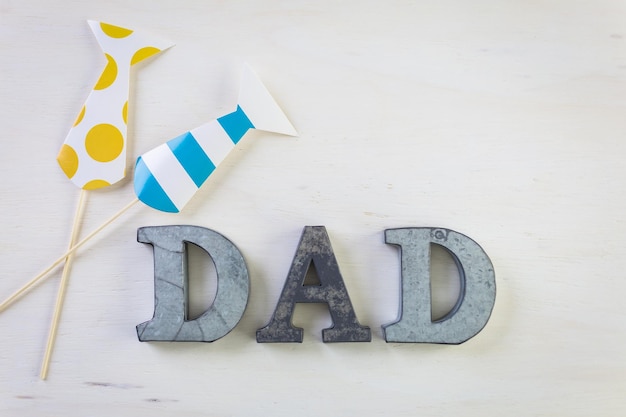 Metal letters DAD on a painted wood background.