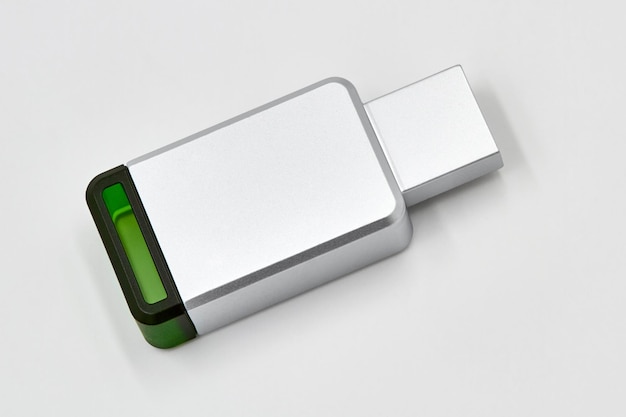 녹색 플라스틱 요소가 있는 금속 연한 회색 USB 스틱 또는 플래시 드라이브