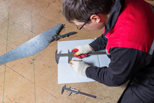 Metal marking locksmith marks a sheet of metal