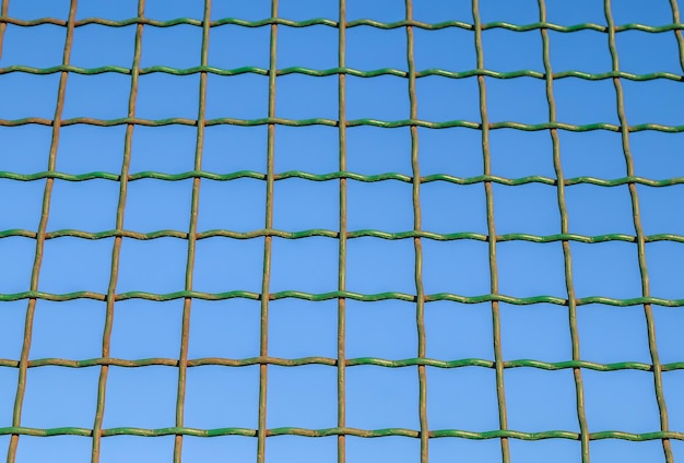 Metal mesh fence against the sky