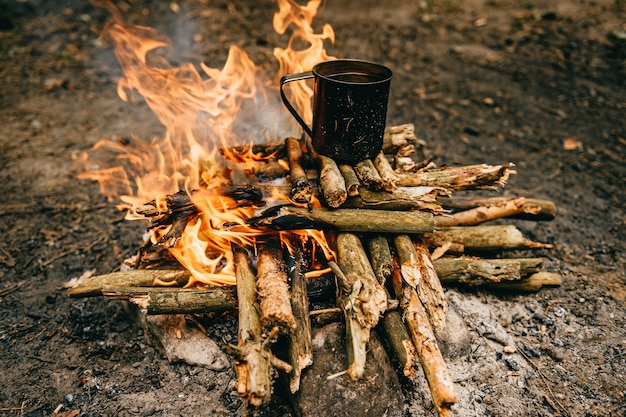 Metal mug heats up on bonfire