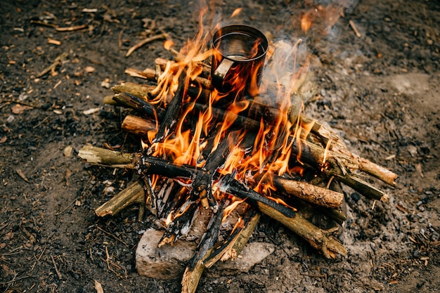 Metal mug heats up on bonfire