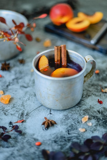 Metal mug with homemade non-alcoholic autumn and winter hot drink from berries and fruits on table