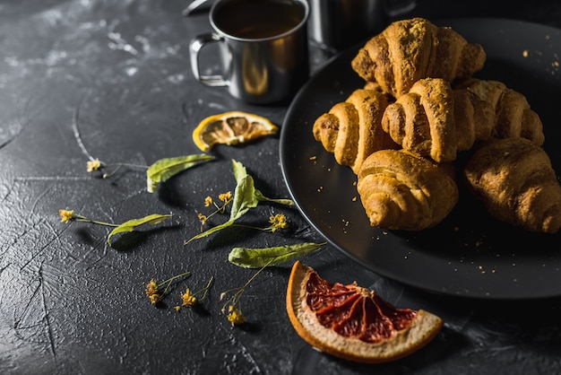 Metal mugs of healthy lemon tea with croissants