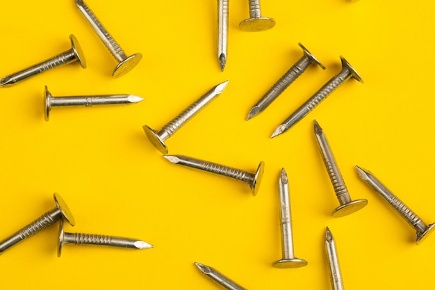 Metal nails closeup lots of nails on a yellow background