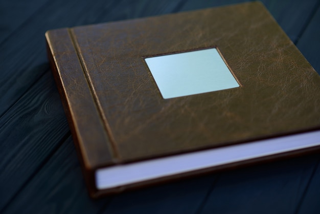 A metal nameplate on the cover of a brown leather photo book