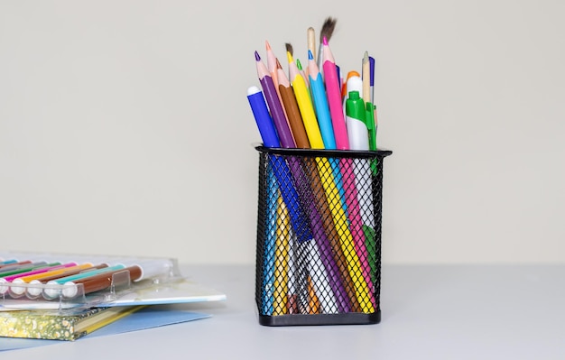 학교 개념으로 다시 색연필이 있는 금속 그물 상자 펜 홀더