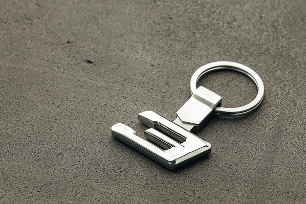 Metal number three car key on dark concrete background