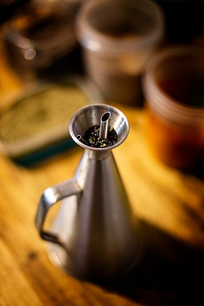 Metal oilcan on wooden table out of focus