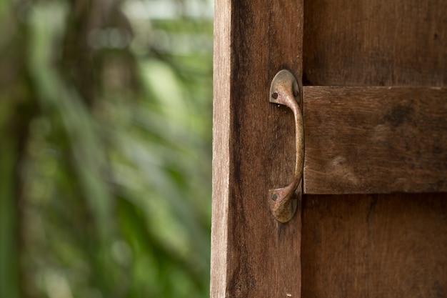 Metal old rusty handle on wooden window