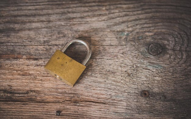 Metal padlock on a rustic wooden desk