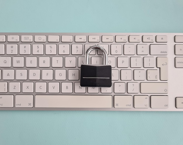 Metal padlock on a white computer keyboard