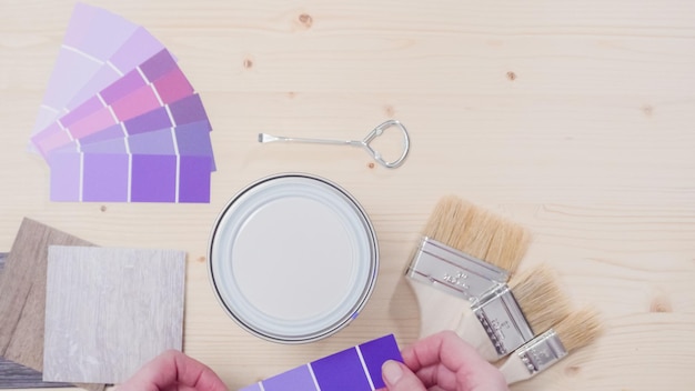 Металлическая краска может с фиолетовой краской и другими инструментами для рисования для проекта улучшения дома.