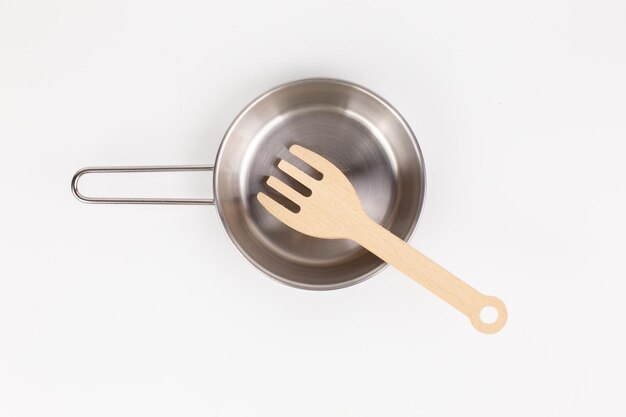 A metal pan with a wooden spatula for cooking