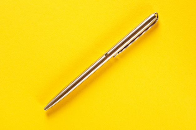 Metal pen isolated on yellow