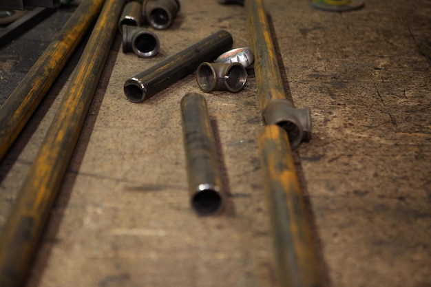 Metal pipes and bars are randomly lying on the old desktop Closeup photo