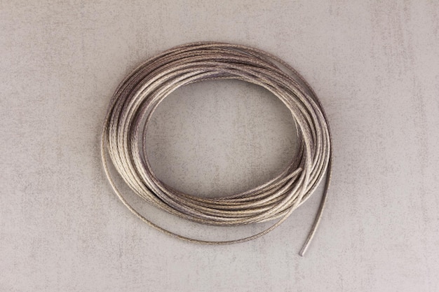 Metal polymer cable in a skein on a gray background top view closeup