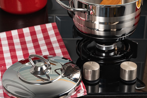 Metal pot on a gas stove burner at home kitchen close up