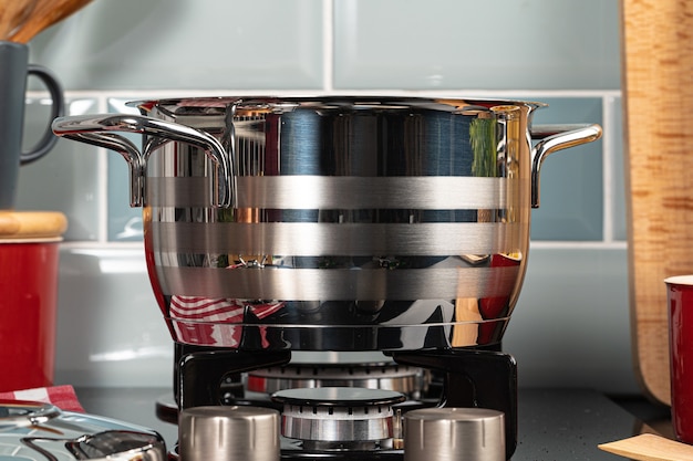 Metal pot on a gas stove burner at home kitchen close up