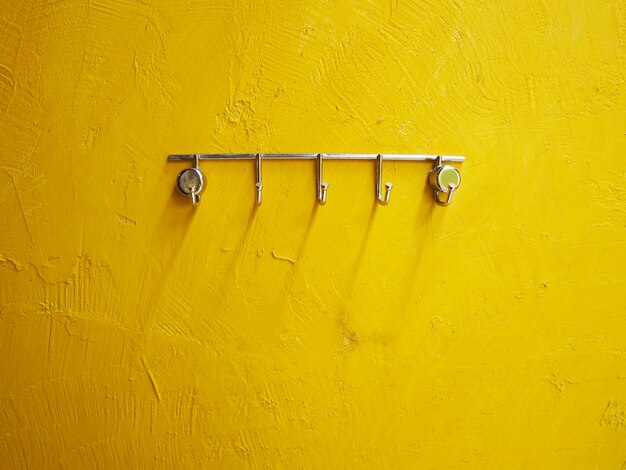 Metal rack over yellow grunge cement wall