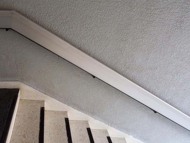 The metal railing near the concrete wall along the staircase