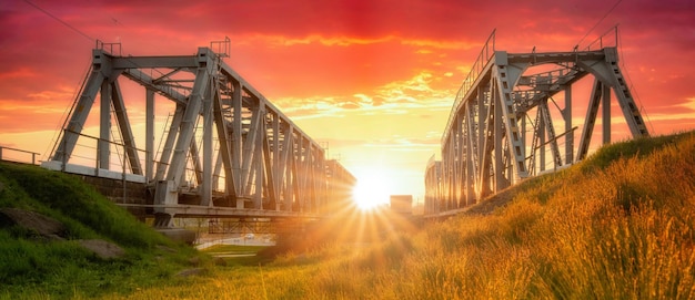 Ponte ferroviario in metallo al tramonto paesaggio industriale