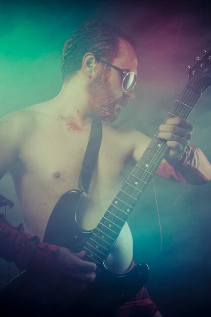Metal, rocker man with electric guitar in a rock concert