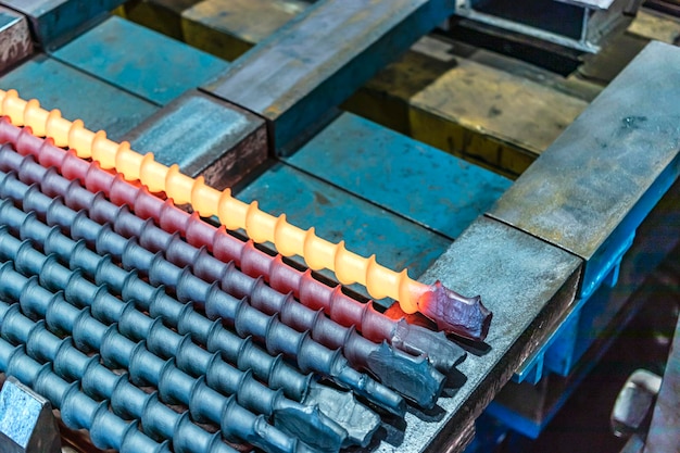 A metal rod heated in an induction furnace after processing hot\
metal cools down metalworking in the industrial workshop at the\
factory