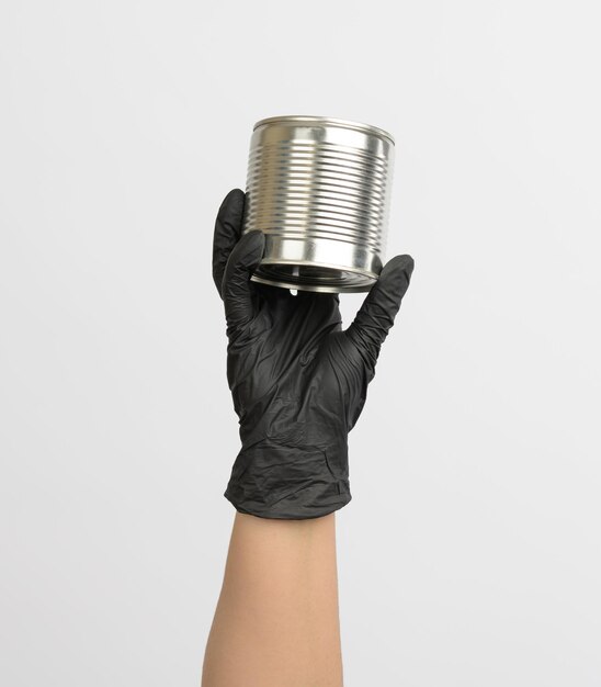 Photo metal round tin can in a female hand on a white background