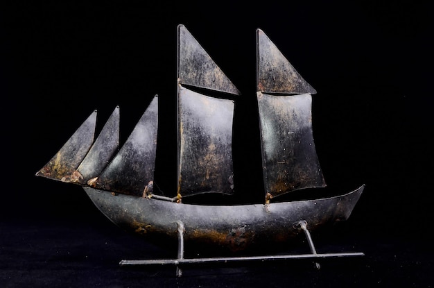 Photo metal sailing boat figurine on a black background