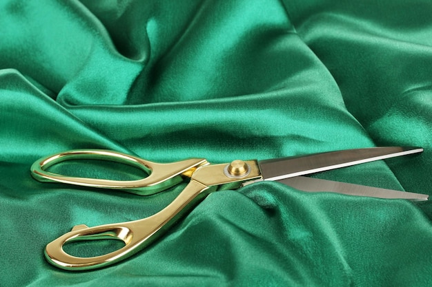 metal scissors on green fabric