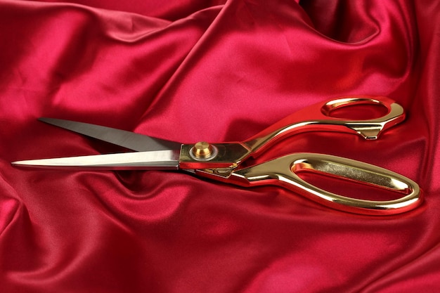 metal scissors on red fabric