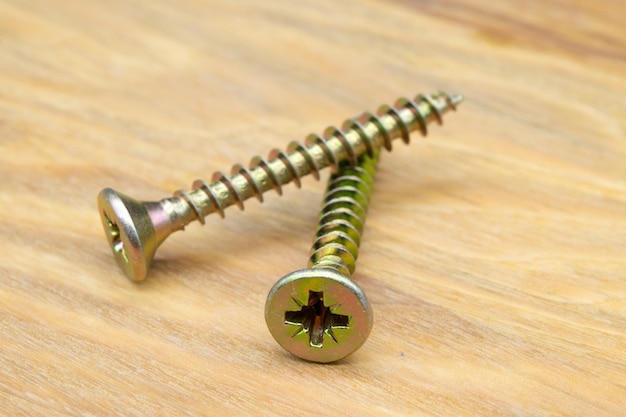 Metal screws for wood Closeup view of metal wood screws on a wooden background