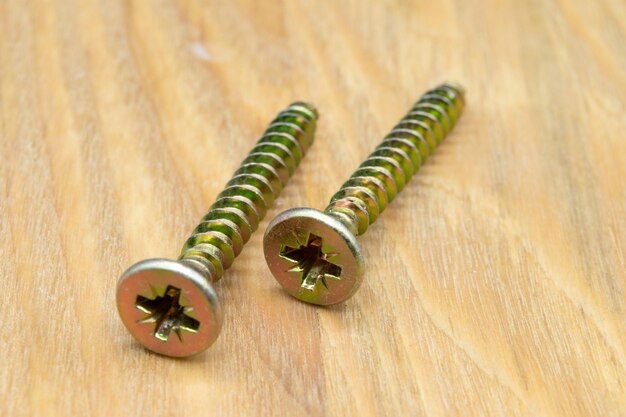 Metal screws for wood Closeup view of metal wood screws on a wooden background